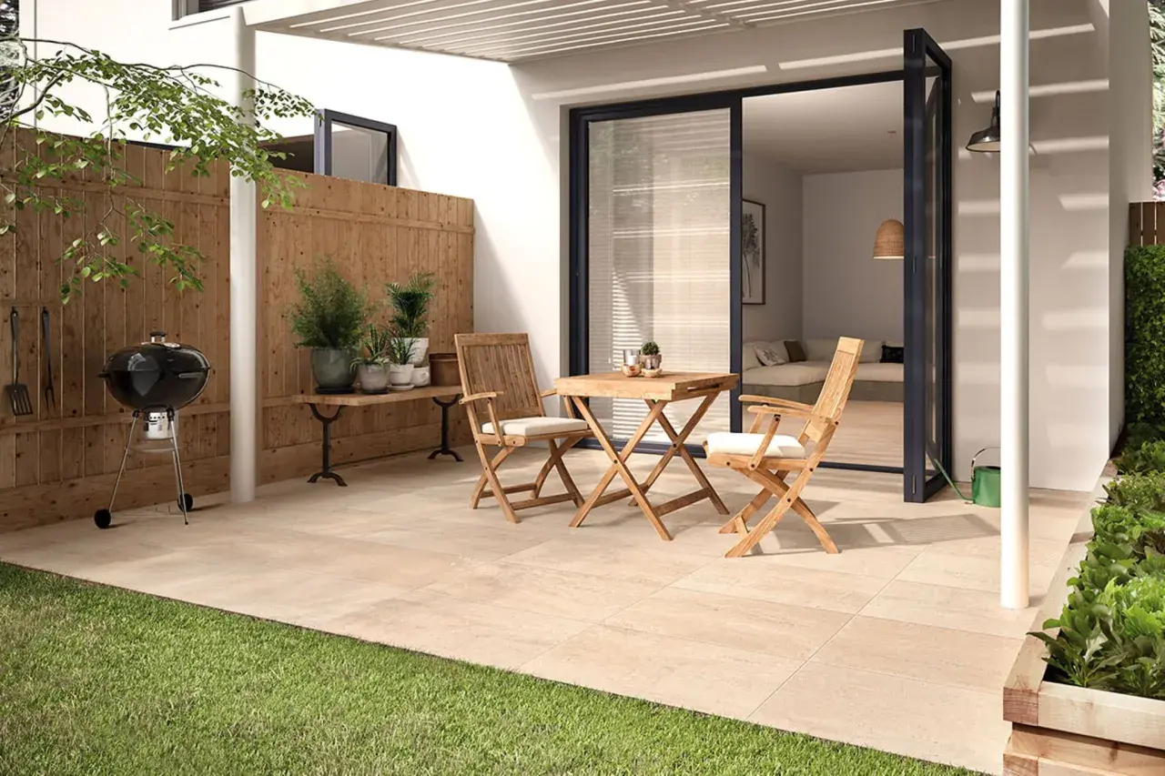 Ein moderner kleiner Garten am Reihenhaus mit Grill, Holztisch und Stühlen. Perfekt für entspannte Stunden.