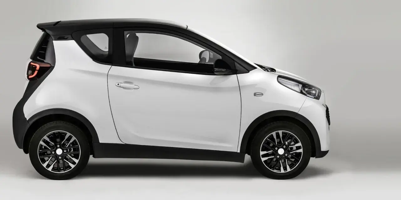 Auto elettrica bianca e nera, modello DR 1.0, vista di lato. Design moderno e compatto.