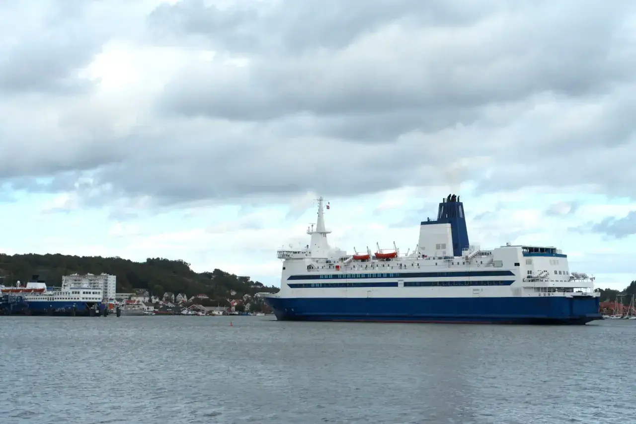 Duży prom pasażerski, podobny do tych kursujących na trasie Dover, zacumowany przy brzegu.