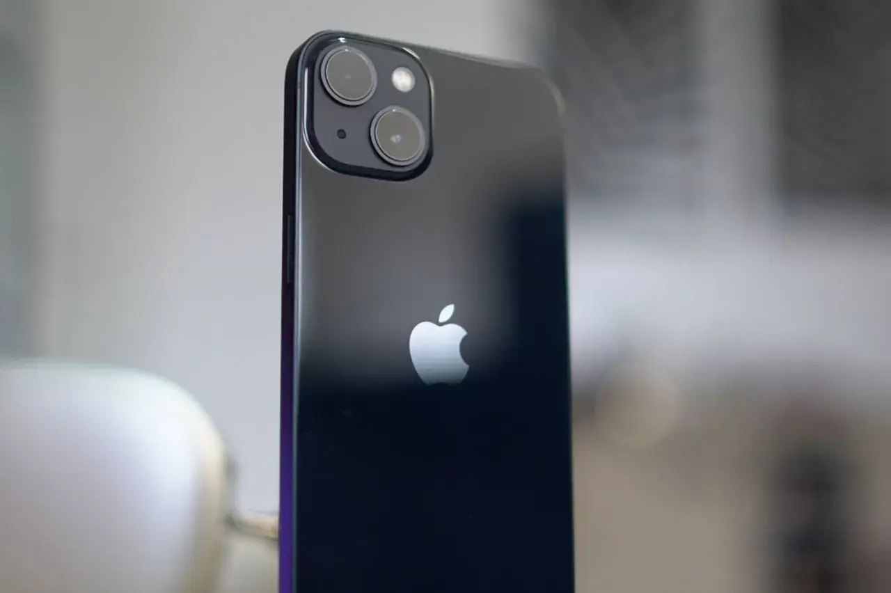 Arrière d'un iPhone 13, avec son logo Apple et le module photo incluant un objectif grand angle.