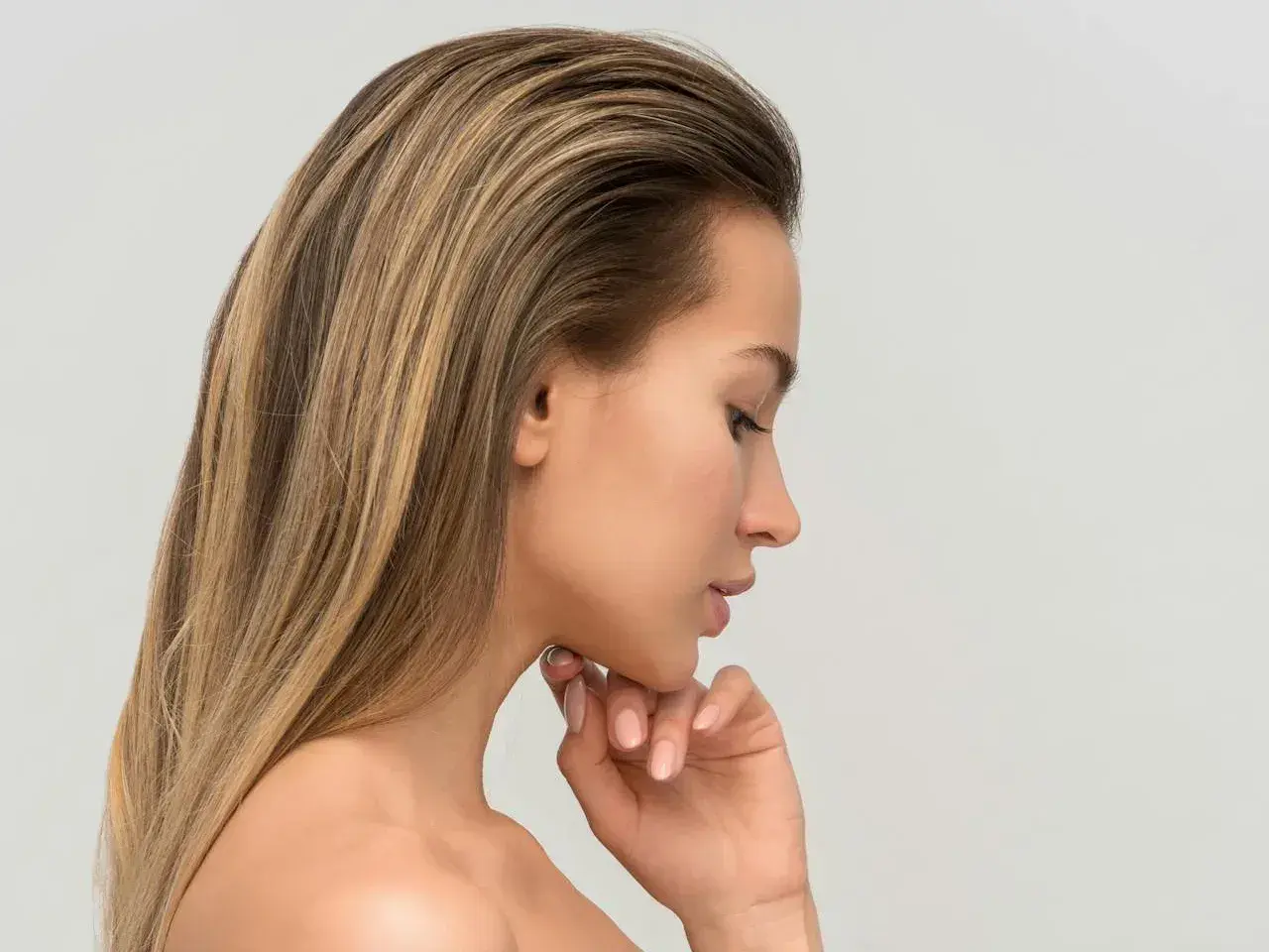 Profil kobiety z długimi, blond włosami. Zabieg mezoterapia igłowa skóry głowy może pomóc w pielęgnacji.