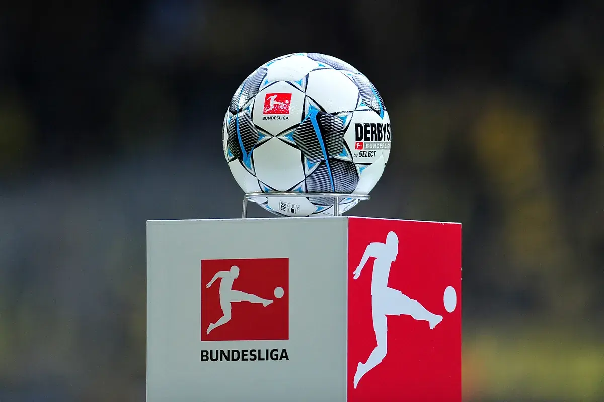 Piłka do gry w piłkę nożną na tle logotypów 2. Bundesliga. Zawodnicy tej ligi już wkrótce rozpoczną emocjonujące mecze.