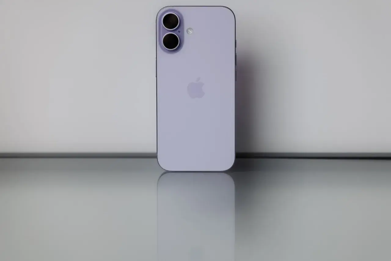 Nowy iPhone 17 biały, z podwójnym aparatem i logo Apple, odbija się na błyszczącej powierzchni.