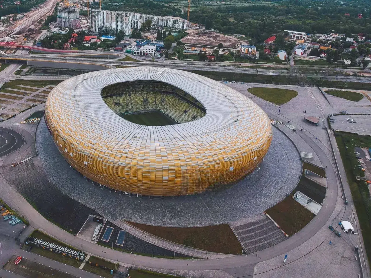 Widok z lotu ptaka na stadion w Gdańsku, z jego charakterystyczną, złotą fasadą. Idealne miejsce na zwiedzanie stadionu gdańsk i poczucie atmosfery wielkich wydarzeń sportowych.