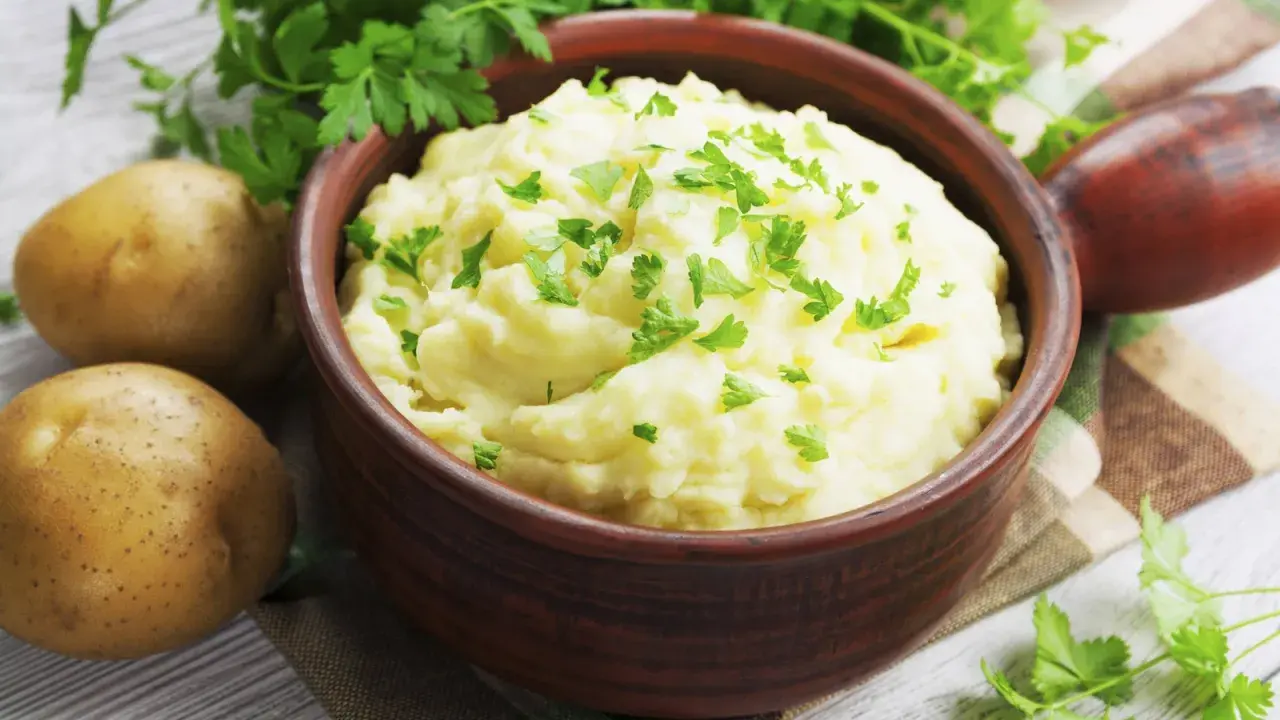 Un cremoso puré de patatas, un acompañamiento perfecto, adornado con perejil fresco.