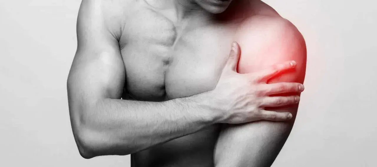 Un homme tient son épaule douloureuse, une longue portion de son bras est marquée en rouge pour indiquer la douleur.