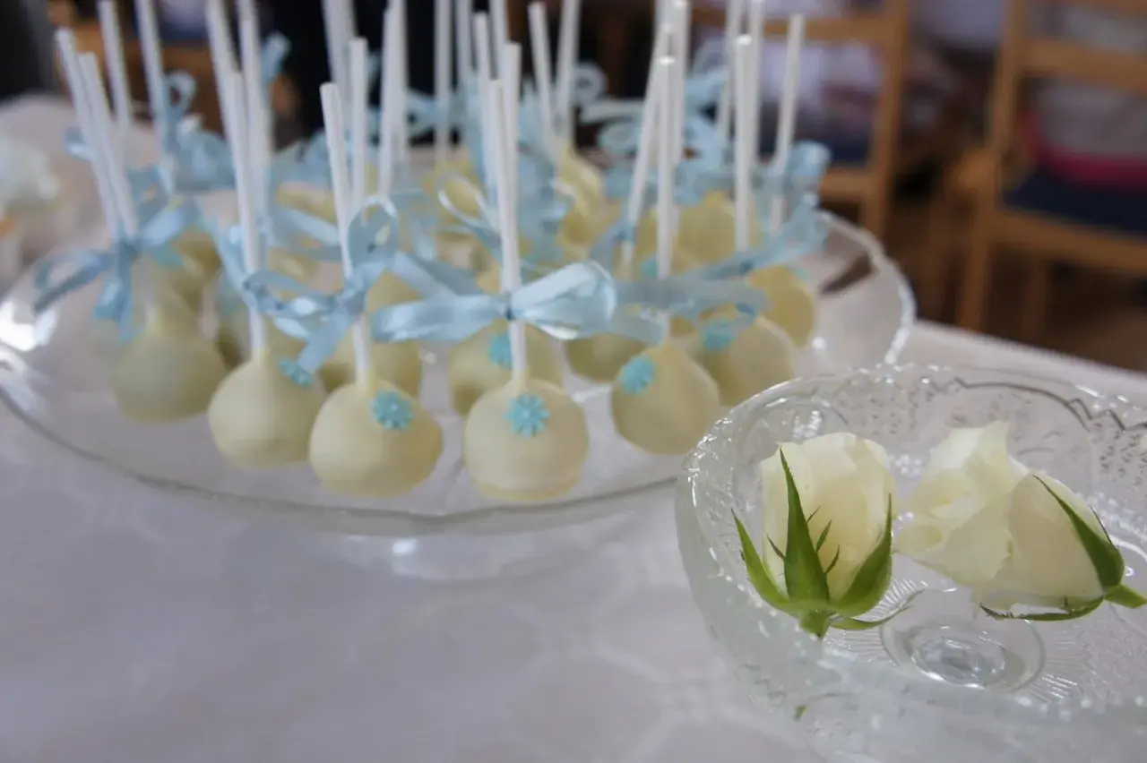 Vita cake pops med ljusblåa rosetter och blommor, perfekta för ett dop. Ett enkelt cake pops recept att prova!