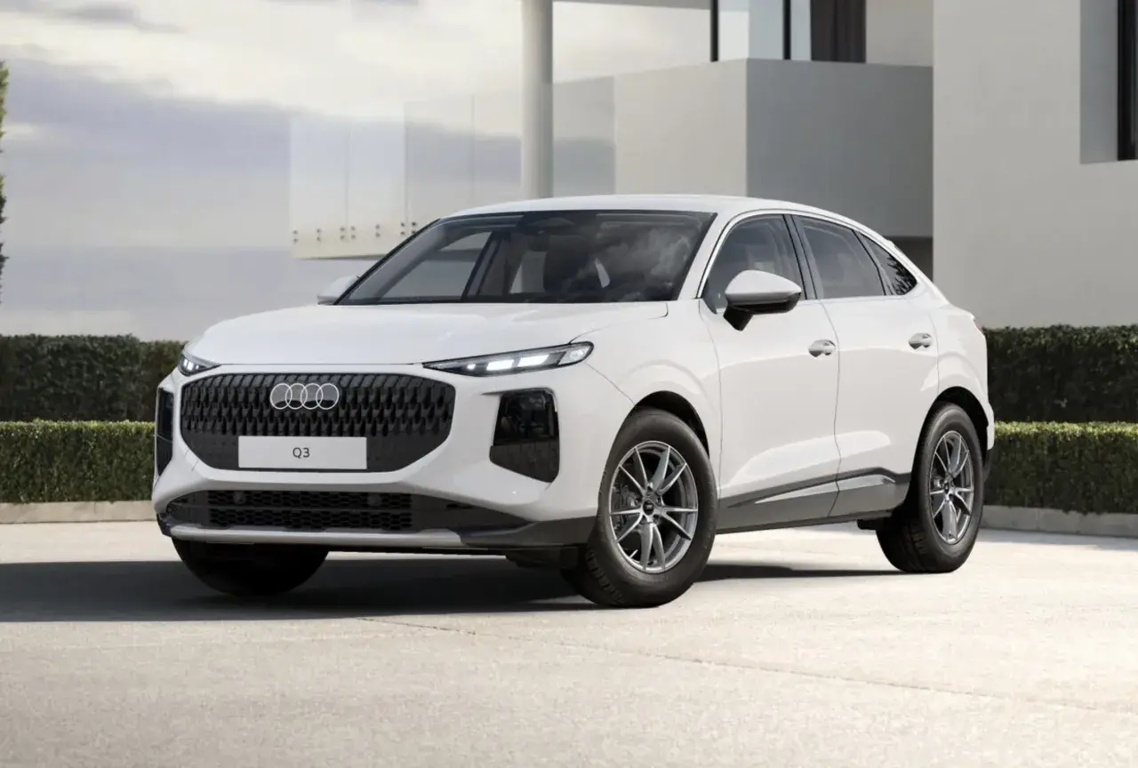 Białe Audi Q3 Sportback na tle nowoczesnego budynku.