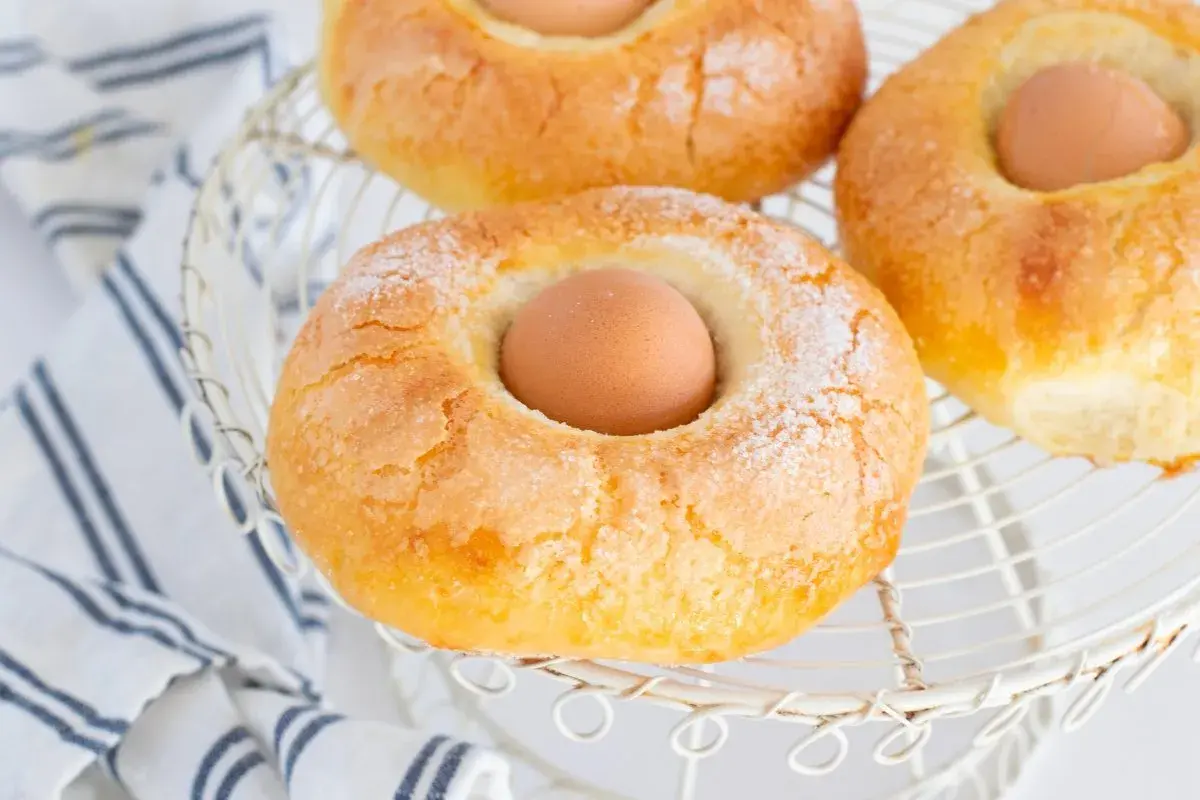 Monas de Pascua doradas y azucaradas, con un huevo cocido en el centro, listas para celebrar la primavera.