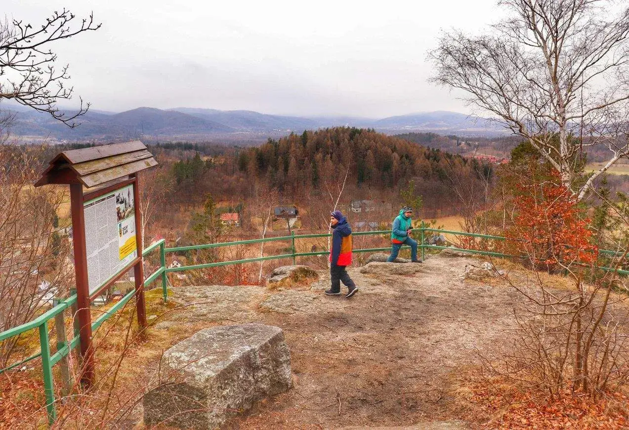 Widok z góry Witosza na jesienny krajobraz. Dwie osoby podziwiają panoramę.