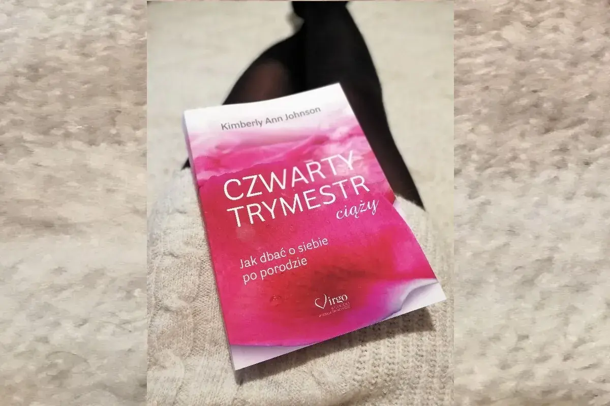 Książka "Czwarty trymestr ciąży" Kimberly Ann Johnson leży na jasnym swetrze.
