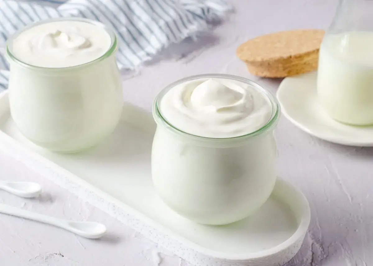 Dos frascos de yogur casero cremoso, listos para disfrutar. Aprende como hacer yogurt casero.