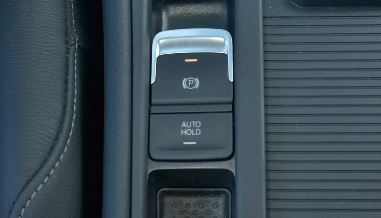 Przycisk auto hold w samochodzie, obok hamulca ręcznego.