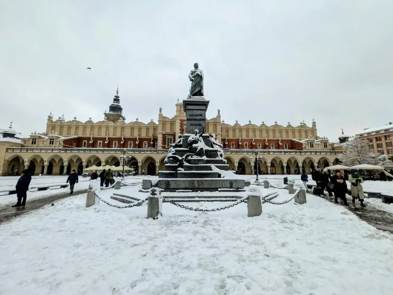 Zimowy spacer po Rynku Głównym w Krakowie. Pomnik Mickiewicza i Sukiennice w śniegu to idealne tło na krótki wypad, nawet jeśli to tylko kraków w dwa dni.