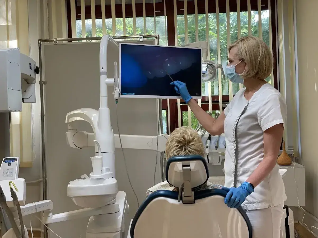 Dentystka pokazuje pacjentowi obraz z kamery wewnątrzustnej. Czy dentysta może wystawić L4? Tak, jeśli stan zdrowia pacjenta tego wymaga.