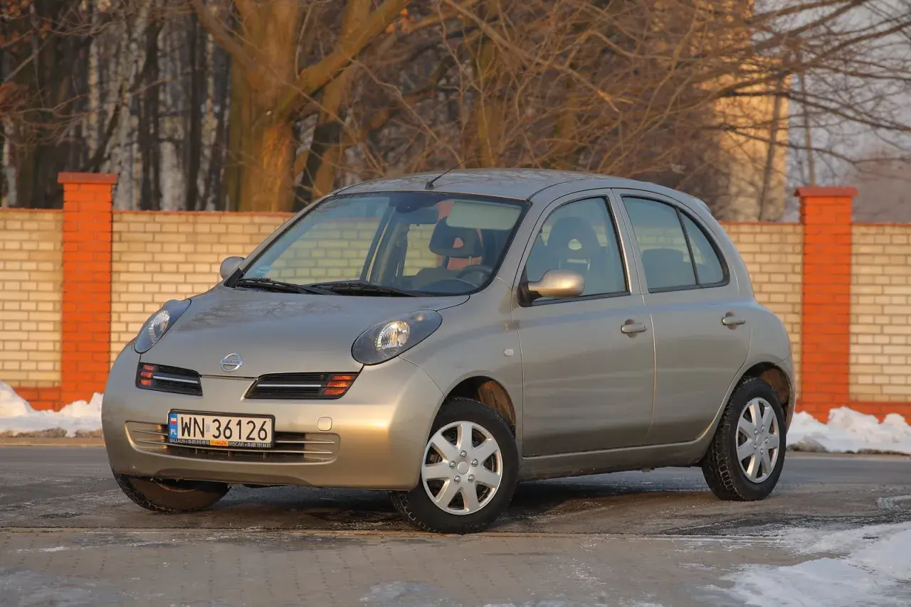 Złoty Nissan Micra K12 z nowymi żarówkami, gotowy na zimowe drogi.