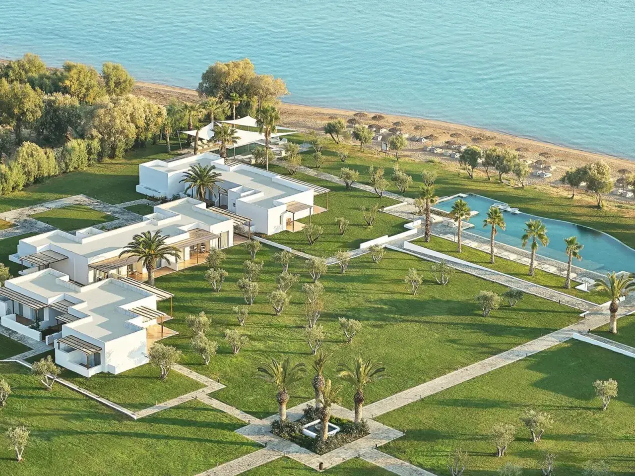 TUI Kids Club Grecotel Casa Marron: weiße Gebäude, Pool, Strand und Palmen. Ein Paradies für Familien.
