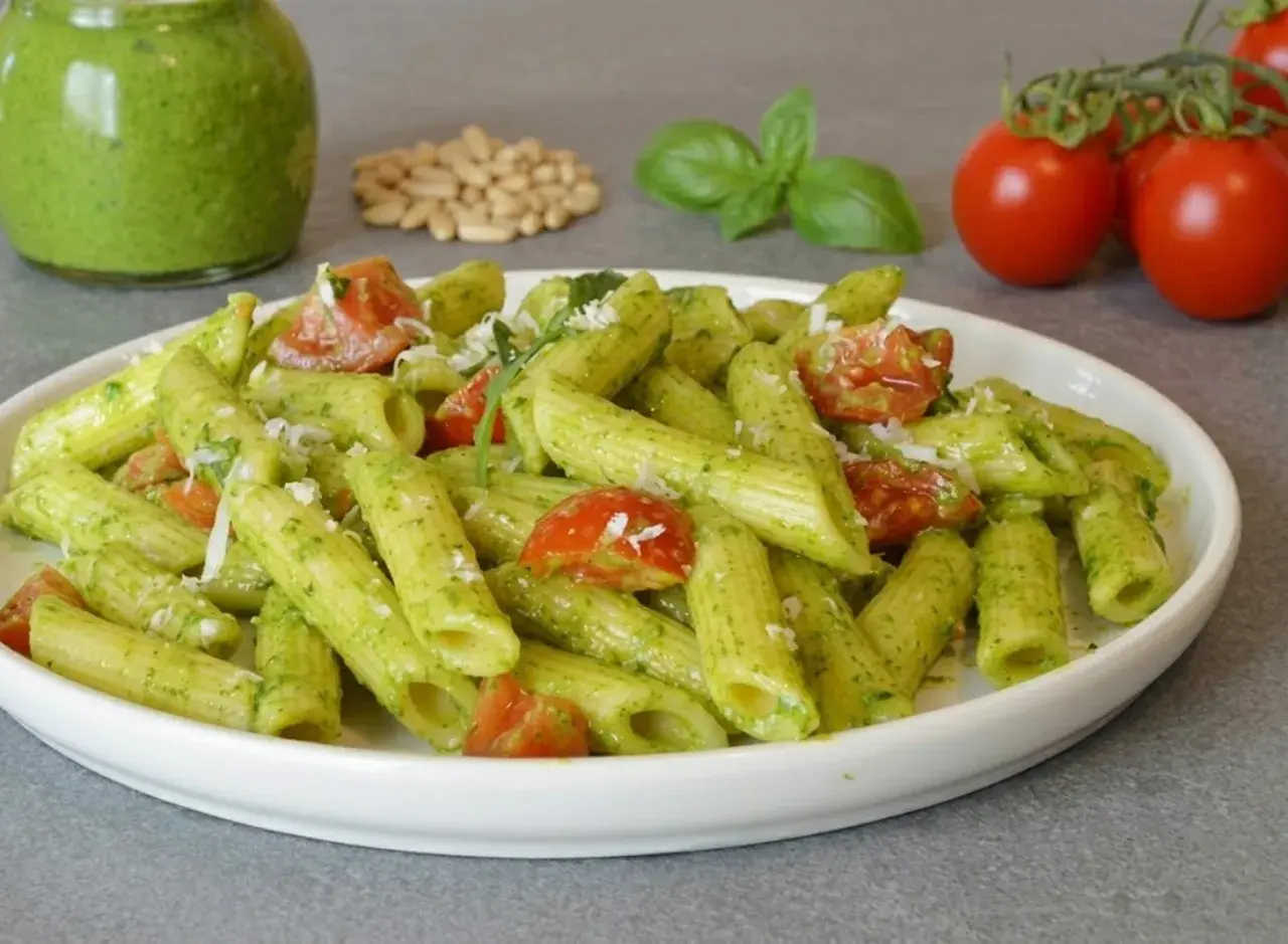 Penne al pesto di rucola con pomodorini freschi e pinoli tostati. Un piatto colorato e saporito.