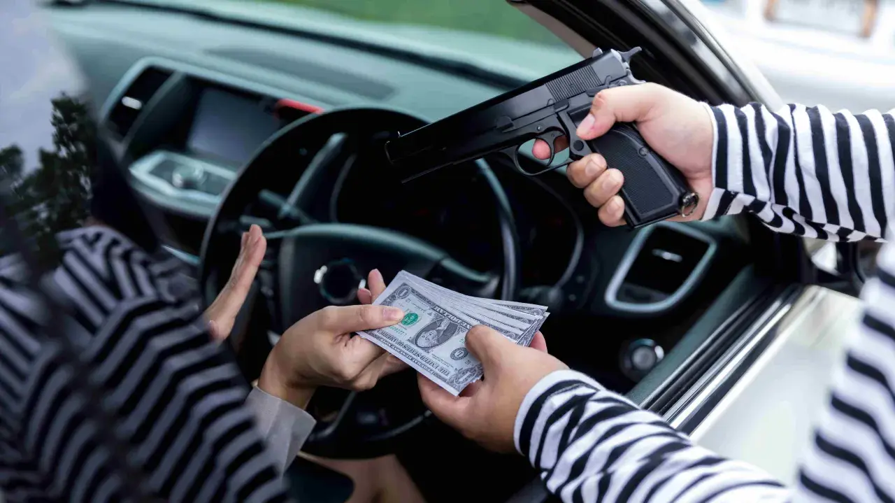 Un homme en pull rayé menace une personne en voiture avec un pistolet, exigeant de l'argent. Scène d'extorsion.