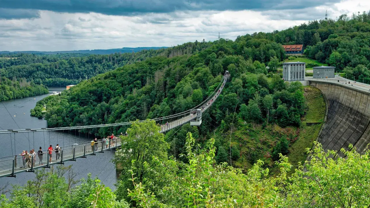 Hängebrücke über die Rappbodetalsperre, ein beliebtes Ausflugsziel im Harz. Menschen spazieren über die Brücke, umgeben von grünen Wäldern.