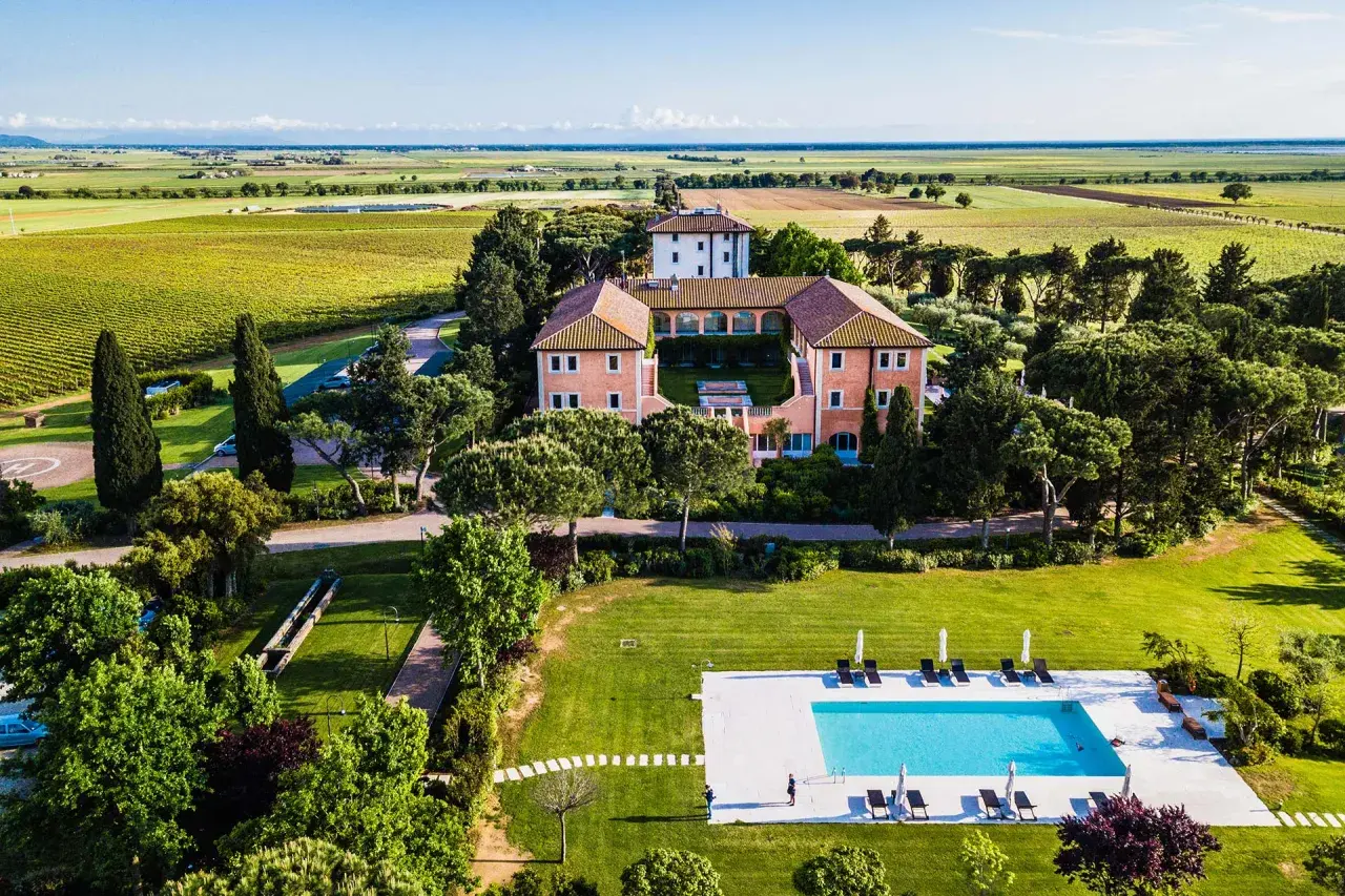 Un elegante wine resort immerso nel verde, con piscina, vigneti e un casale storico.