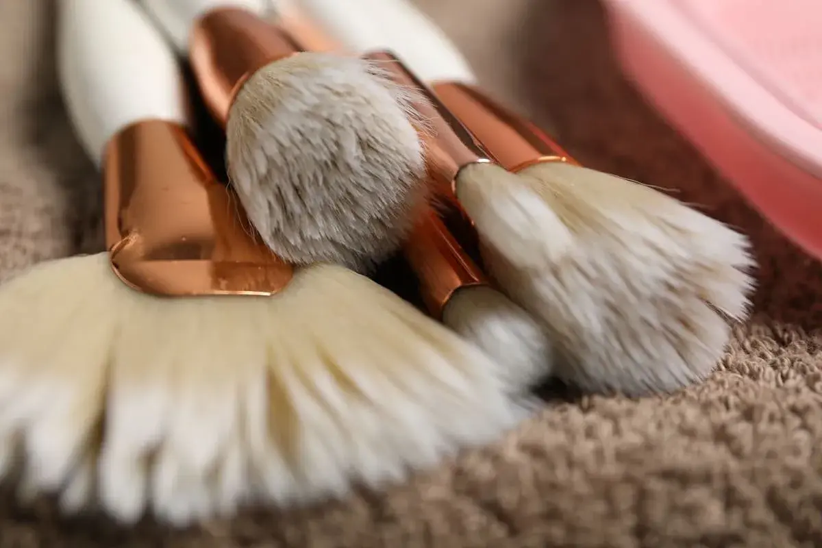 Set de brochas de maquillaje con mangos blancos y detalles dorados, listas para aprender como limpiar brochas de maquillaje.