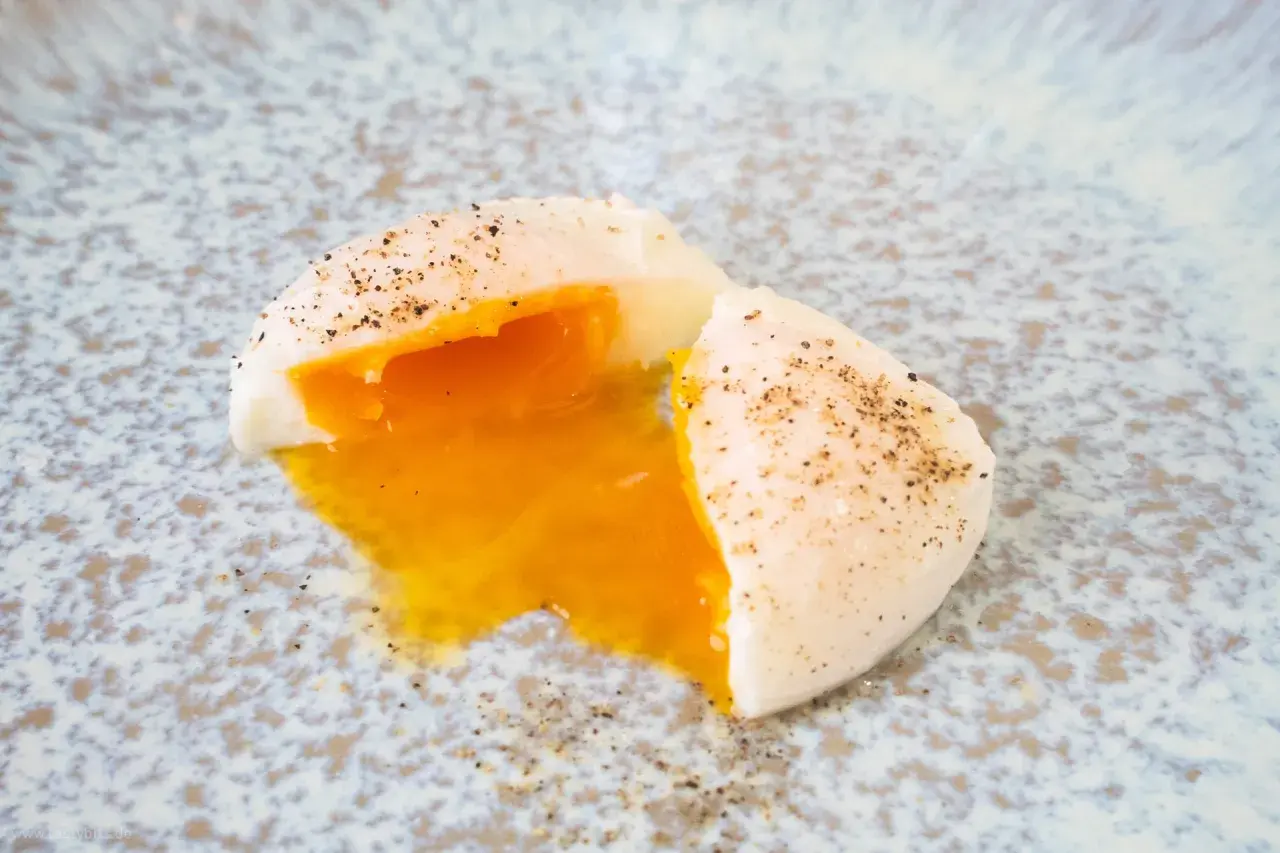 Perfekt pochiertes Ei mit flüssigem Eigelb, bestreut mit Pfeffer. Ein einfaches pochierte eier rezept für jeden Tag.