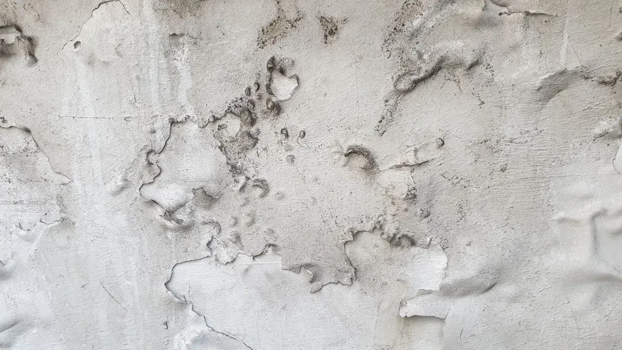Abblätternder Putz auf Mauerwerk, gezeichnet von Salpeterablagerungen.