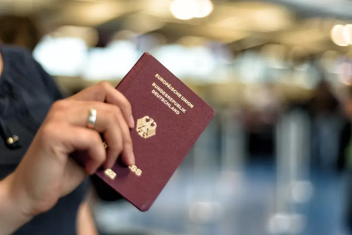 Ein deutscher Reisepass, der nass geworden ist, wird von einer Hand gehalten. Die Seiten sind leicht gewellt.
