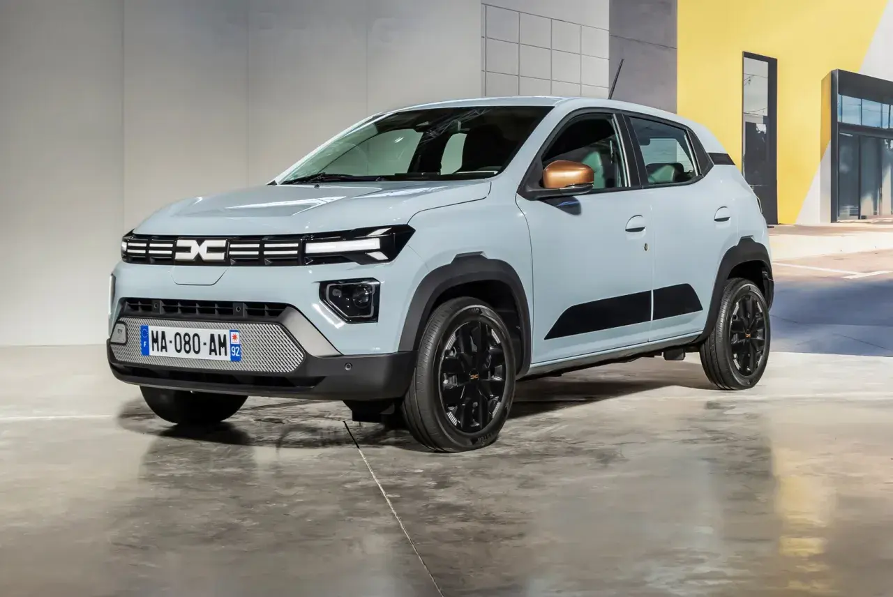 Nowa Dacia Spring w jasnoszarym kolorze, z czarnymi akcentami i miedzianymi lusterkami, prezentuje się nowocześnie.