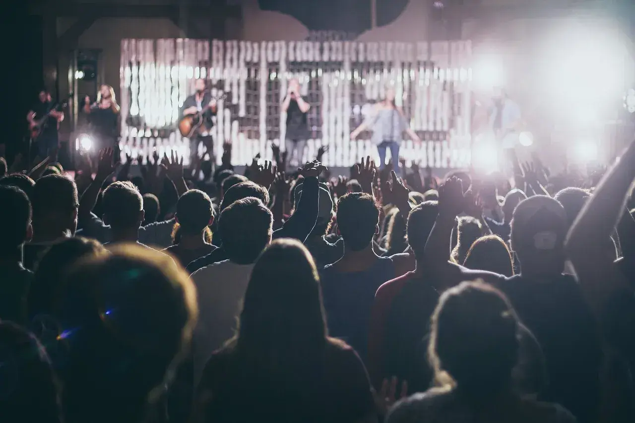Koncert, tłum z rękami w górze. Na scenie zespół, wokalistka zachwyca sopran głosem.