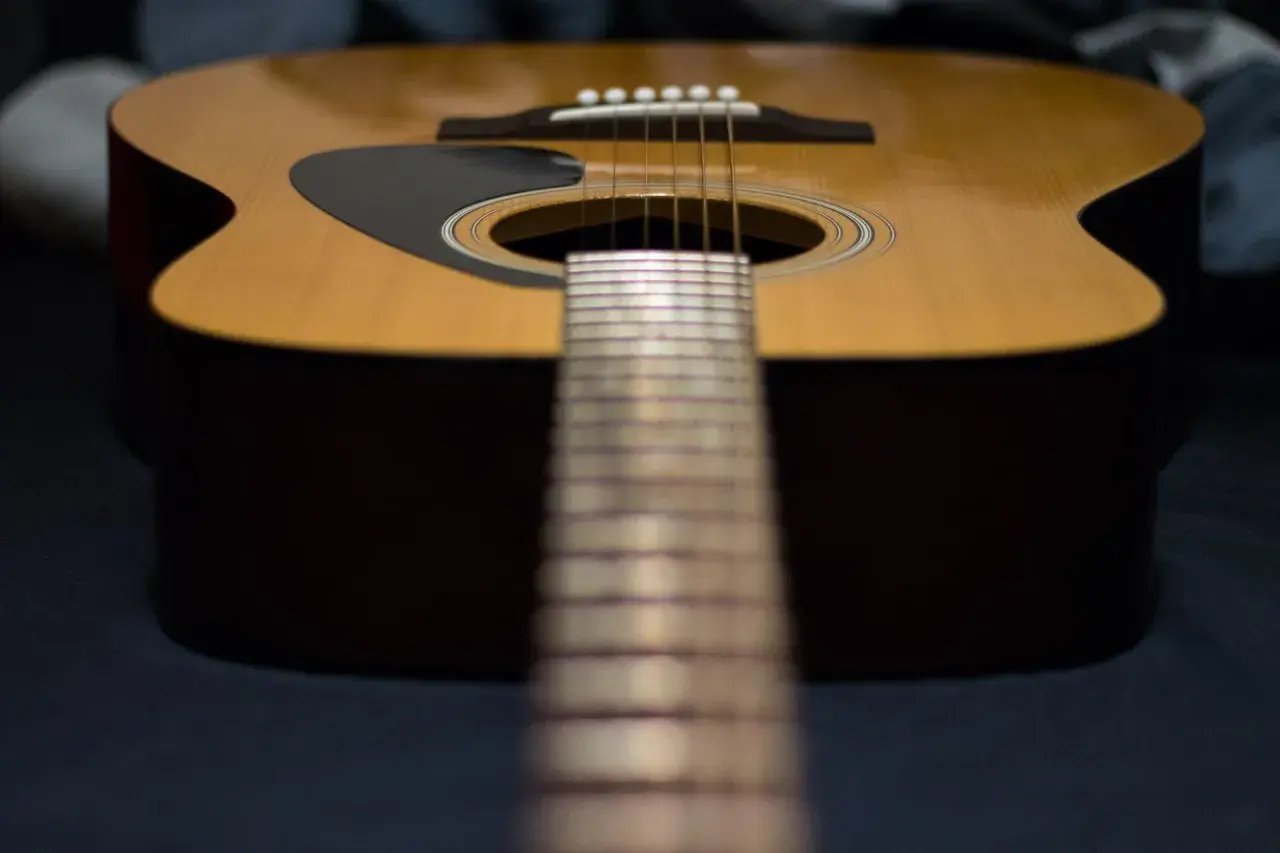 Nahaufnahme einer Akustikgitarre mit Fokus auf die Saitenlage.