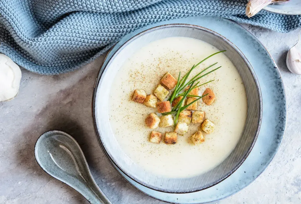 Velouté crémeux garni de croûtons dorés et de ciboule fraîche. Une recette soupe réconfortante, prête à être dégustée.