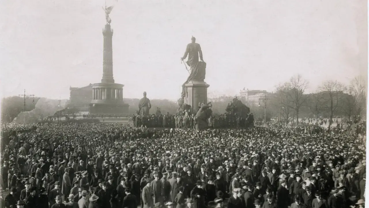 Menschenmenge vor dem Siegessäule-Denkmal in Berlin, ein Symbol der revolutionären Stimmung der Revolution 1918.