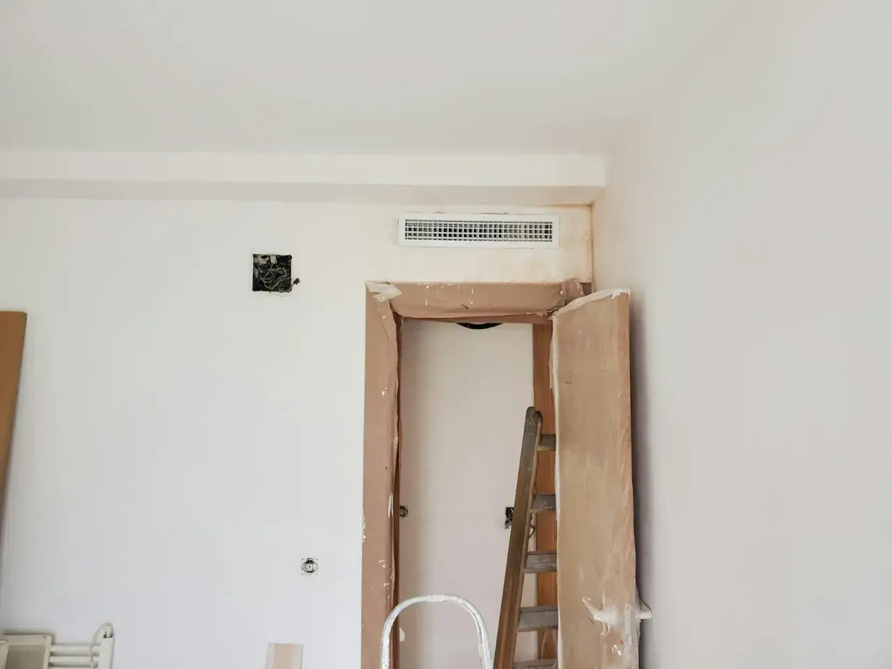 Instalación de rejilla para montaje de aire acondicionado sobre puerta en obra.