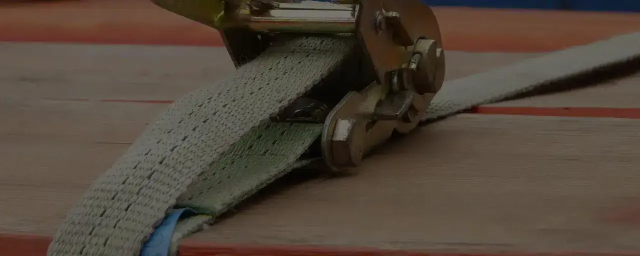 Spanngurt sichert Transportgut auf Ladefläche. Robuste Ratsche hält die Fracht sicher.