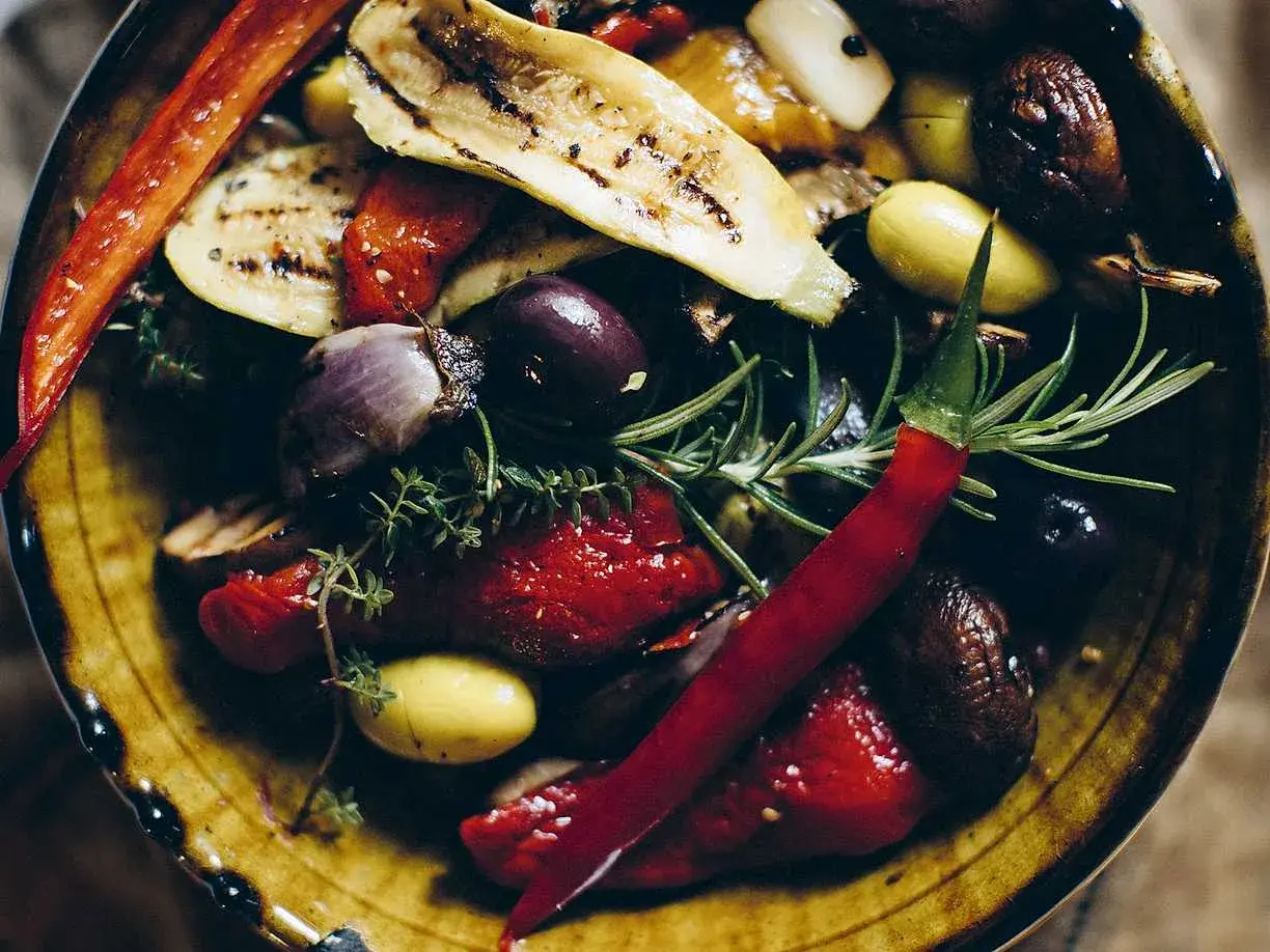 En skål med grillade grönsaker, oliver och chili. Perfekt som antipasti recept.