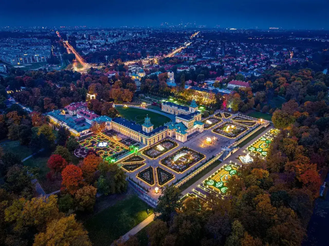 Nocne ogrody świateł Warszawa w Wilanowie. Pałac i iluminowane ogrody w jesiennej scenerii.