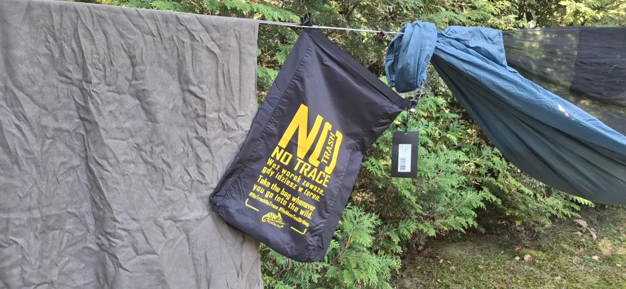 Czarny worek na śmieci z napisem "NO TRACE" przypomina o zasadach "leave no trace" podczas wypoczynku na łonie natury.