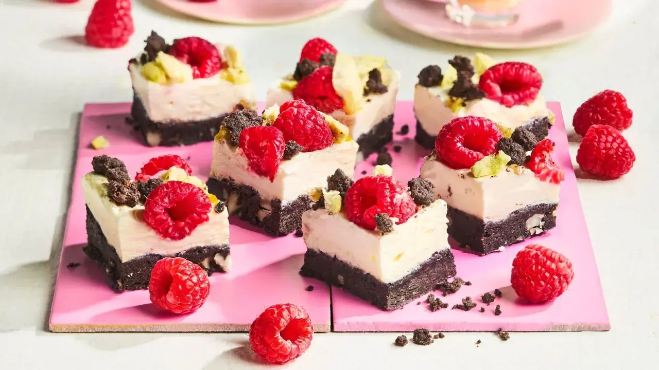 Kleine, cremige Kuchenstücke mit Himbeeren und Schokostückchen, perfekt für den Sommer.