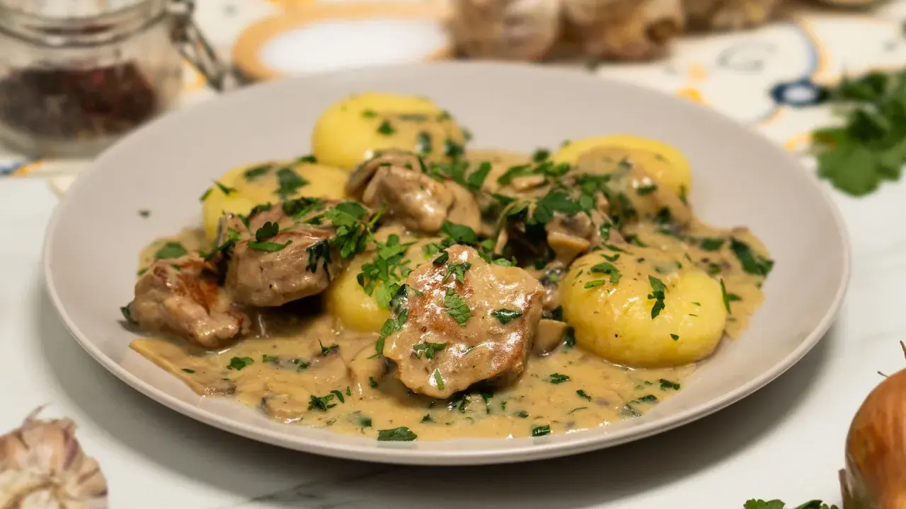 Polędwiczki w sosie pieczarkowym z ziemniakami, posypane natką pietruszki. Pyszne danie obiadowe.