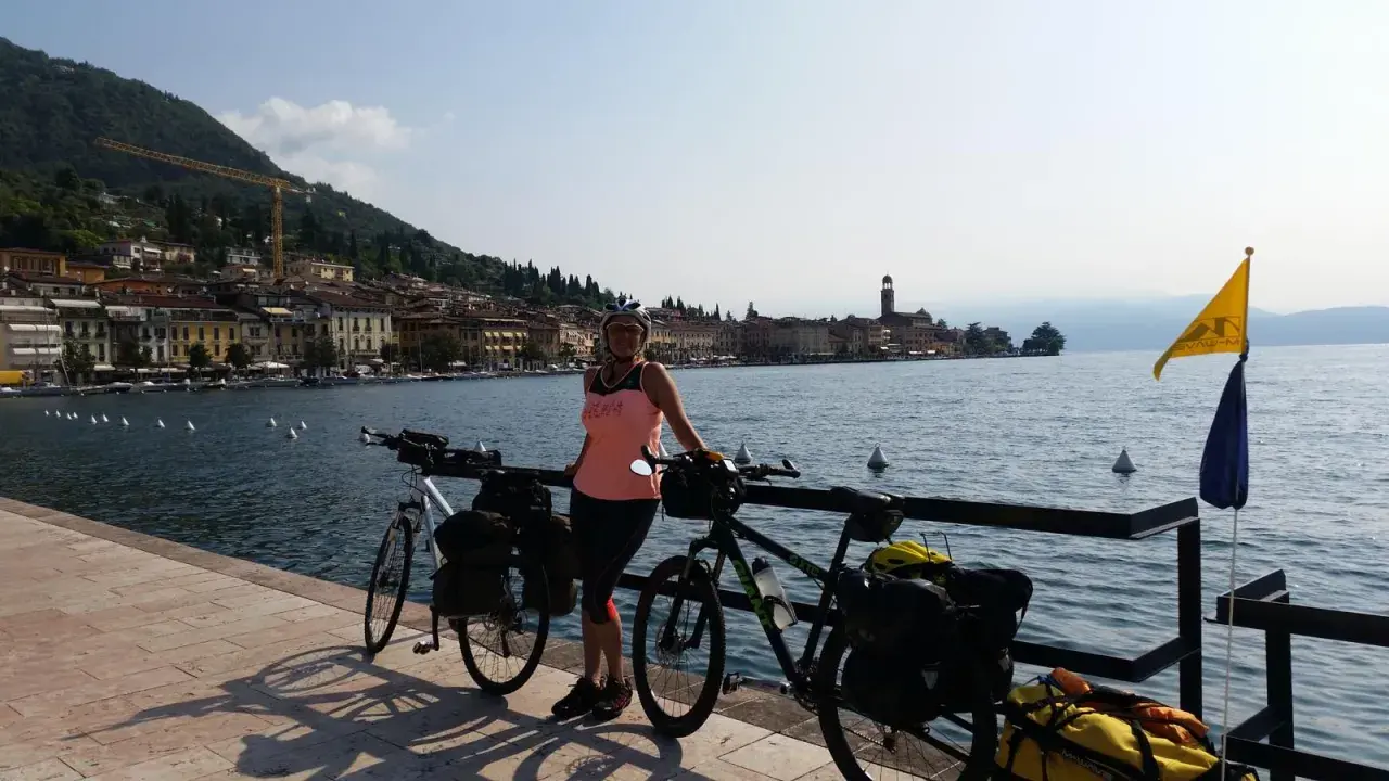 Donna con biciclette da cicloturismo sul lungolago di San Felice del Benaco, pronta per le sue passeggiate.