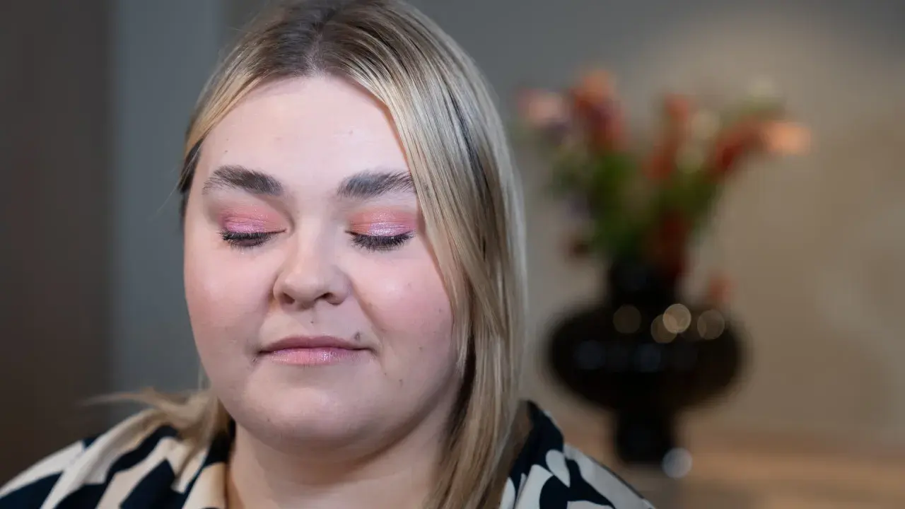 En närbild på en kvinna med rosa skimrande ögonskugga på sina hooded eyes.