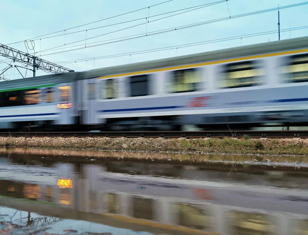 Pędzący pociąg Intercity, odbijający się w kałuży. Nauczyciel z legitymacją może liczyć na zniżki.