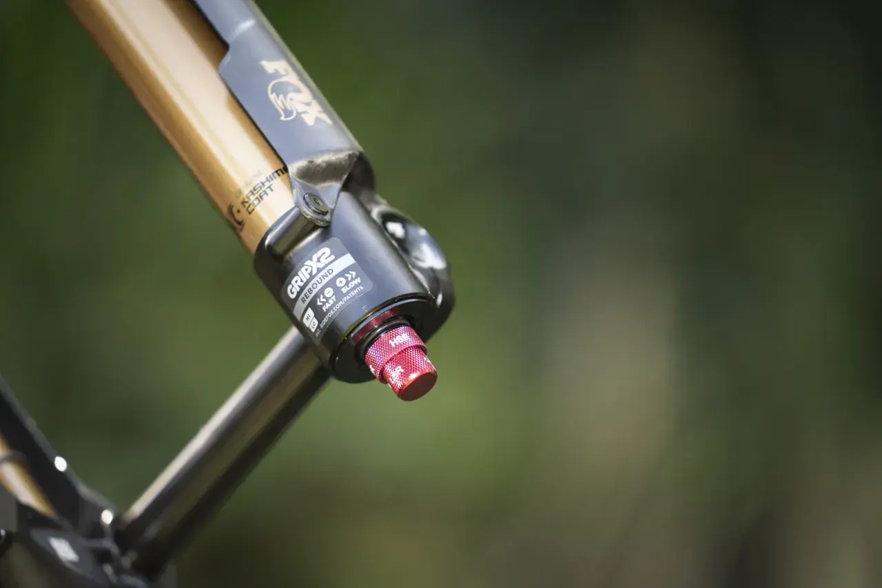 Close-up of a gold and black Fox 36 FIT4 fork with Kashima Coat, featuring the GRIP2 damper and a red adjustment knob.