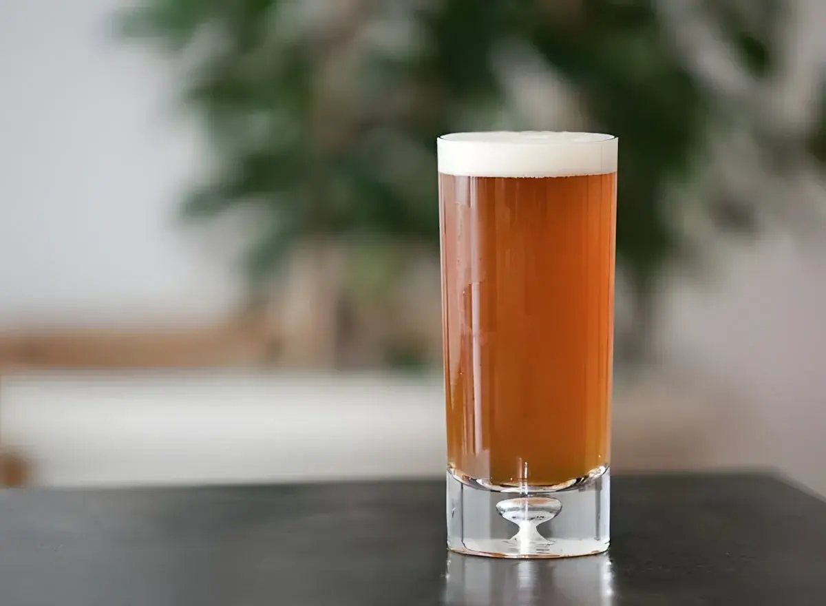 Ein Glas bernsteinfarbenes Pale Ale mit weißem Schaum. Perfekt für ein selbstgebrautes Pale Ale Rezept.