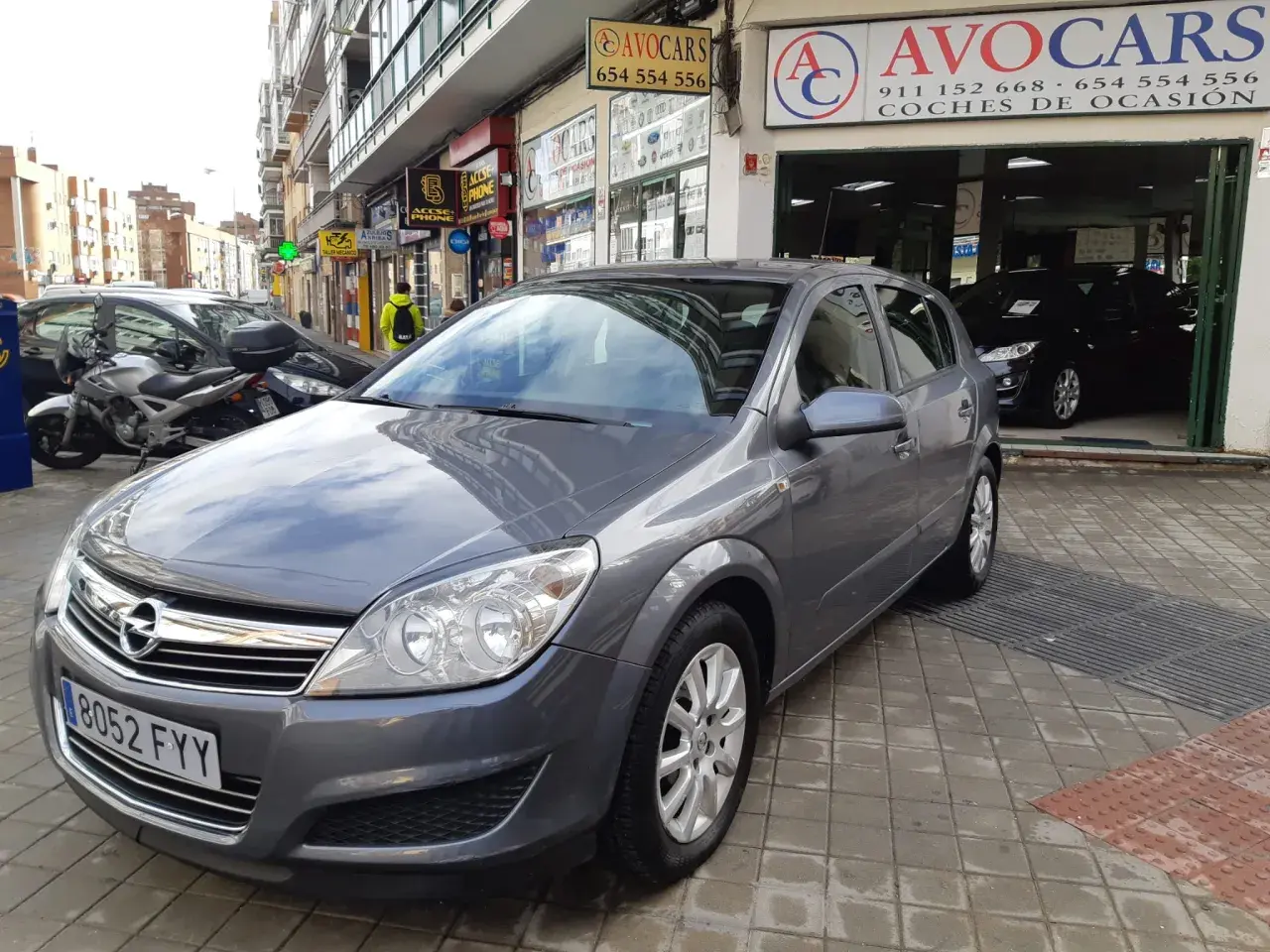Opel Astra 1.7 CDTI 110CV gris aparcado frente a concesionario de coches de ocasión AVOCARS.