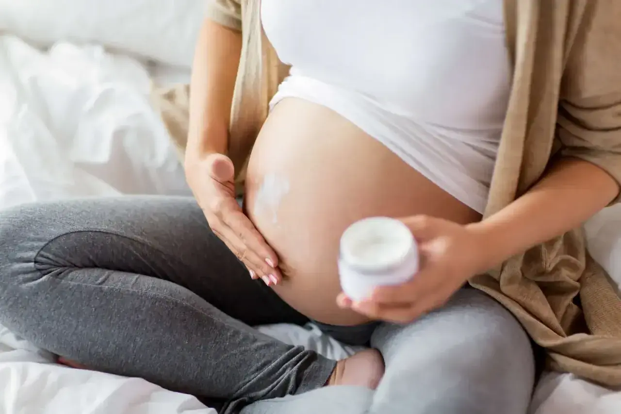 Gravid kvinna smörjer magen med kräm. Vissa krämer innehåller salicylsyra, vilket kan vara bra att veta för dig som är gravid.