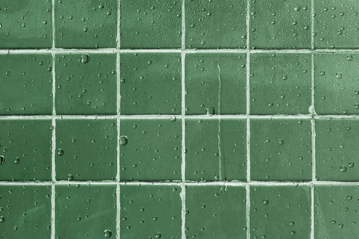 Gouttes d'eau sur un carrelage vert, montrant l'efficacité d'un traitement pour imperméabiliser un carrelage poreux.
