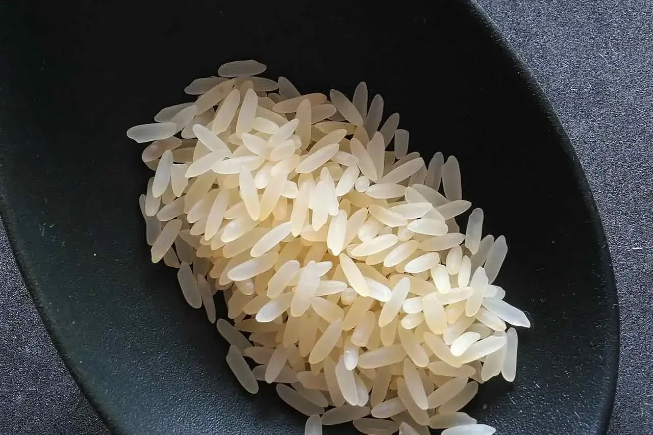 Chicchi di riso originario pronti per la cottura, in una ciotola scura.